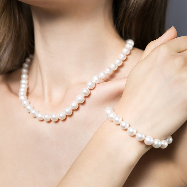 Vue du bracelet comtesse portée par mannequin taille des perles 9mm perles semi rondes couleur blanc nacré . ce bracelet existe en plusieurs longueur 18/18 cm
présenté ici avec collier comtesse de même taille de perles formant une belle parure  Fermoir forme haricot en argent 925